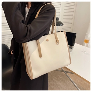 Minimalist beige tote bag with brown trim shown in a professional office setting
