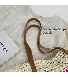 Detail of durable brown leather shoulder straps on a beige woven straw beach tote bag