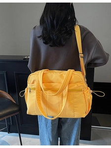 Large bright yellow travel duffel bag with shoulder straps and multiple compartments