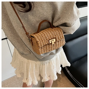 Model view of a vintage straw woven square bag with brown leather strap and gold lock