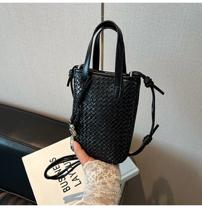 Dettaglio mini borsa nera intrecciata con tracolla a nodi e texture in pelle incrociata