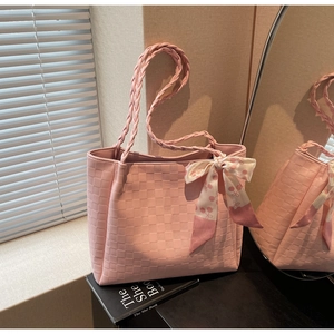 Roze shopper met ruitreliëf en decoratieve zijden sjaal met kersenprint op boeken