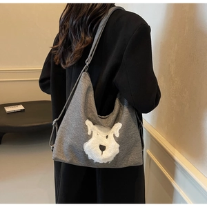 Detail of grey knit crossbody bag featuring a plush Schnauzer puppy patch with shoulder strap