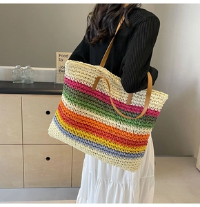 Detailed side view of colorful woven rainbow tote bag with brown leather handles
