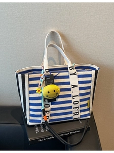 Large striped canvas tote bag with a yellow smiley charm and blue patterned straps