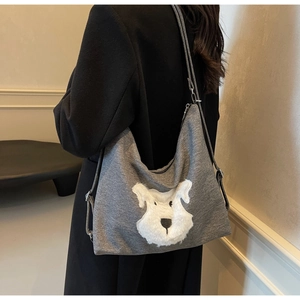 Detail of grey knitted tote bag with white plush dog applique and adjustable strap