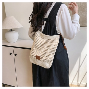 Vue détaillée du sac cabas en crochet beige avec étiquette en cuir marron sur le côté