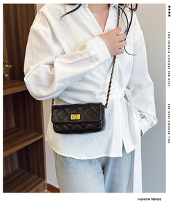 Détail du sac bandoulière matelassé noir avec chaîne dorée et fermoir rotatif en métal