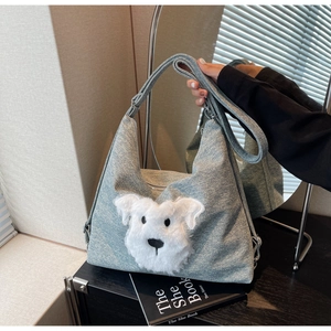 Detailed view of light blue fabric handbag featuring a white plush dog head and silver buckle