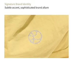 Gros plan du logo circulaire argenté sur un sac à dos en tissu jaune texturé