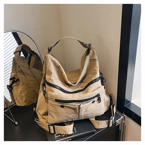 Detail of khaki nylon tote bag with multi-zipper pockets and adjustable shoulder strap
