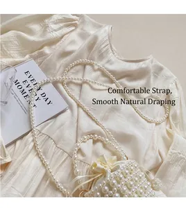 Detailed top view of a cream woven pearl bucket bag with drawstring closure and strap