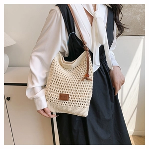 Détail du sac cabas en crochet fait main avec motifs ajourés et étiquette en cuir