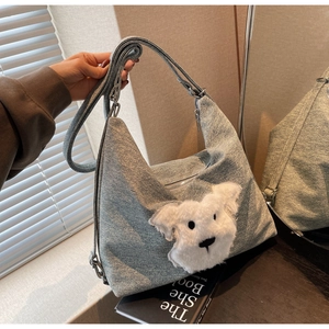 Detail of blue denim tote bag with 3D plush dog head and adjustable metal strap