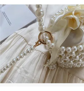 Detail of pearl woven bucket bag showing satin drawstring closure and gold hardware