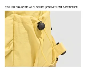 Détail d'un arrêt de cordon en plastique noir et du tissu en nylon jaune d'un sac à dos