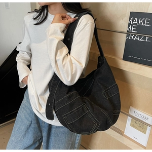 Detail view of black denim crossbody bag with adjustable metallic eyelet strap for women