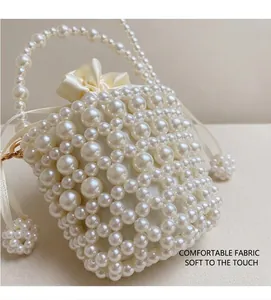 Close-up of pearl beaded bucket bag with ivory satin drawstring liner and strap
