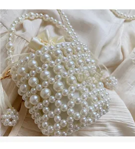 Close-up of pearl beaded bucket bag with ivory satin drawstring liner and strap