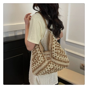 Detail view showing beige and brown woven texture of a large vacation shoulder tote bag