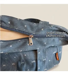 Close-up of smooth silver zipper and heart embroidery on blue denim tote bag