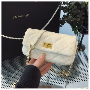 Détail du sac bandoulière matelassé blanc avec fermoir rotatif doré et chaîne