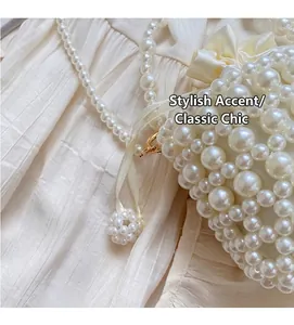 Detailed view of woven pearl bucket bag with satin bow and pearl chain strap