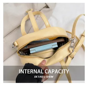 Interior view of yellow leather mini pillow bag showing phone and makeup storage