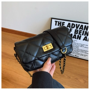 Détail du sac à bandoulière matelassé noir avec fermoir doré et bandoulière chaîne