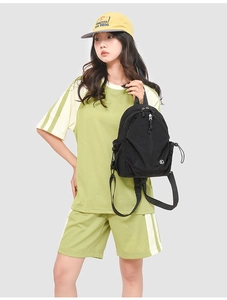 Détail du sac à dos en nylon noir avec coutures géométriques et cordon de serrage latéral