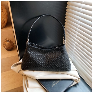 Gros plan sur la texture tressée noire et les détails argentés du sac à bandoulière