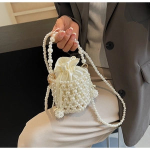 Detailed view of the hand-woven pearl bucket bag with a satin drawstring inner pouch