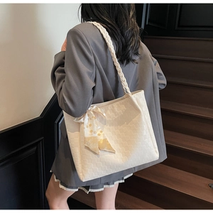Detail van beige geweven shopper met gebloemde sjaal en dikke gevlochten banden