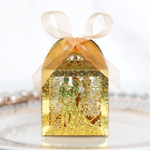 Golden laser-cut wedding candy box with glitter finish and champagne ribbon bow