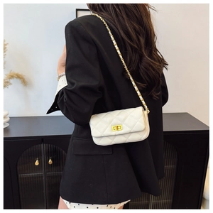 Détail du sac à bandoulière matelassé blanc avec chaîne dorée et fermoir en métal