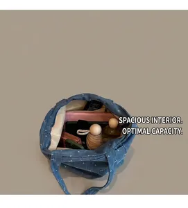 Macro shot of spacious denim tote interior filled with daily essentials and tablet