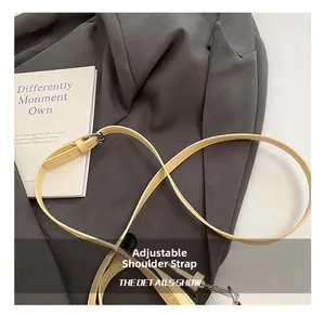 Detail of adjustable pale yellow PU leather shoulder strap with a metal buckle