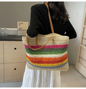 Detailed back view of a rainbow woven straw tote bag with brown leather straps for summer