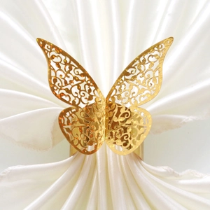 Détail de l'anneau de serviette papillon doré scintillant avec motif découpé