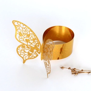 Close-up of golden hollow butterfly napkin ring with sparkling glitter finish for wedding