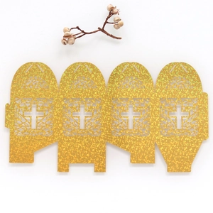 Flat lay of laser-cut glitter gold cross boxes for religious weddings and christenings