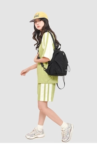 Vue avant d'un sac à dos en nylon noir avec compartiments zippés porté par un mannequin