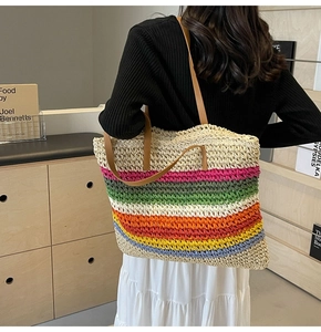 Rainbow woven straw tote bag detail showing colorful stripes and brown leather strap