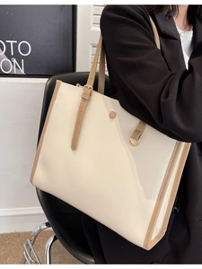 Minimalist beige tote bag with brown trim and long shoulder strap for women