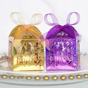 Detail of laser-cut Mr & Mrs wedding candy boxes with champagne gold and purple glitter finish