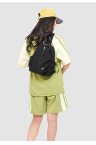 Vue arrière d'un mannequin portant un sac à dos noir en nylon imperméable avec logo blanc