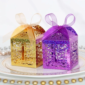 Detail of laser-cut cross pattern and glitter texture on festive candy boxes with ribbons
