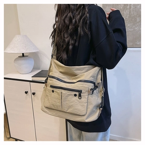 Detailed close-up of khaki canvas tote bag with multi-pocket utility design and black zippers