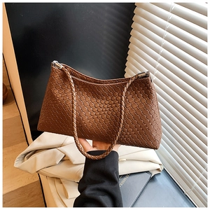 Détail de la texture en cuir tissé et de la boucle métallique de ce sac porté épaule marron