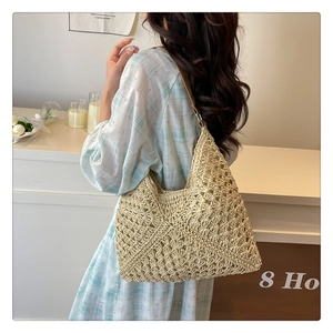 Detail of hollow woven texture and brown leather strap on beige knit tote bag